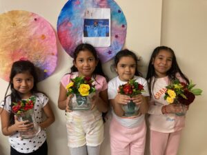 Four little girls each holding flowers as a gesture of gratitude