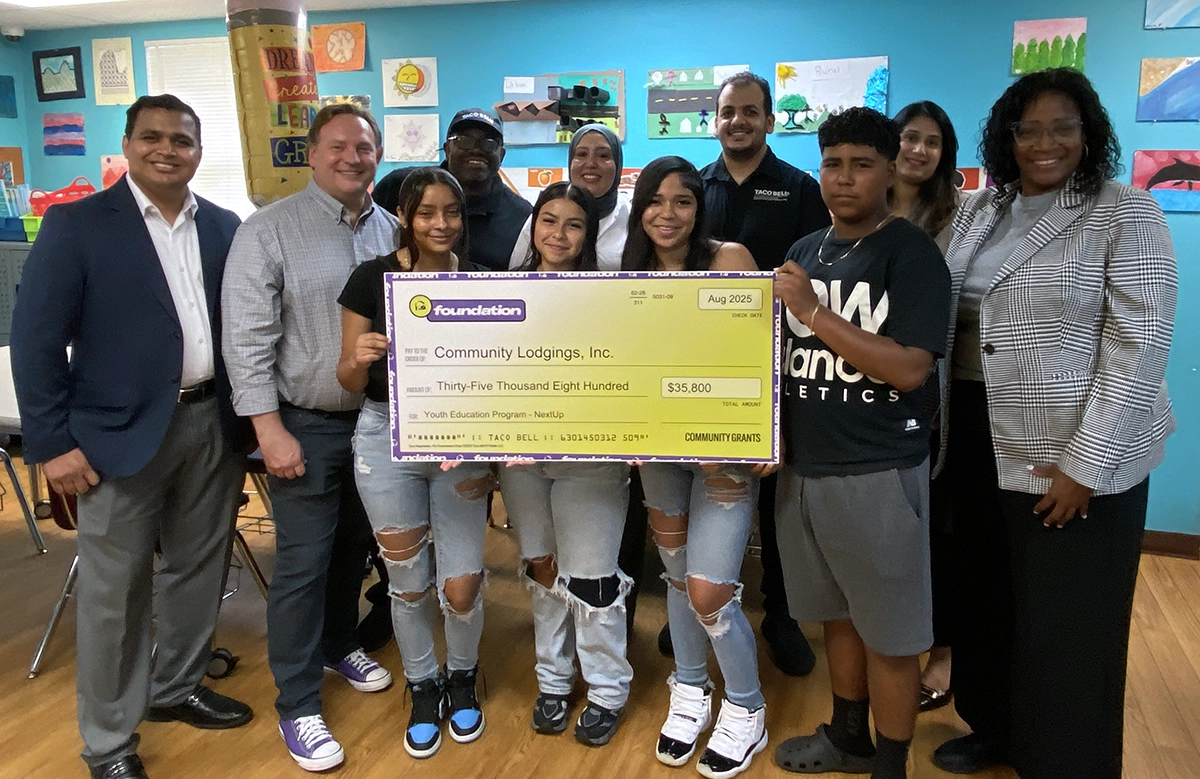 Group photo of Community Lodgings youth and adults holding a presentational check for $35,800.